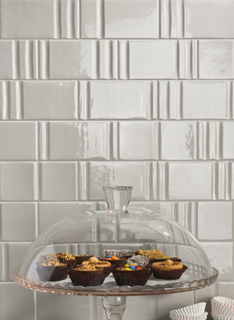 Track Pewter Decor Mix — grey sculpted tiles behind glass cake stand
