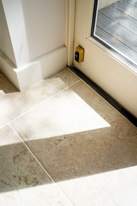 Baverstock Buff limestone-effect porcelain tile detail beside a glazed door